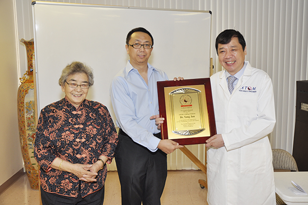 Visiting DAOM professor holding placque with President Yen